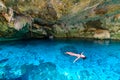 Cenote Dos Ojos in Quintana Roo, Mexico. People swimming and snorkeling in clear blue water. This cenote is located close to Tulum