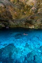 Cenote Dos Ojos in Quintana Roo, Mexico. People swimming and snorkeling in clear blue water. This cenote is located close to Tulum