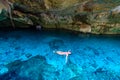 Cenote Dos Ojos in Quintana Roo, Mexico. People swimming and snorkeling in clear blue water. This cenote is located close to Tulum