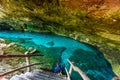 Cenote Dos Ojos in Quintana Roo, Mexico. People swimming and snorkeling in clear blue water. This cenote is located close to Tulum