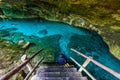 Cenote Dos Ojos in Quintana Roo, Mexico. People swimming and snorkeling in clear blue water. This cenote is located close to Tulum