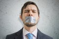 Censorship concept. Young man is silenced with duct tape over his mouth Royalty Free Stock Photo