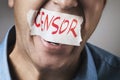Censorship in society. A man is trying to scream, but his mouth is sealed with adhesive tape with the words censor