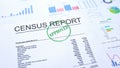 Census report approved, hand stamping seal on official document, statistics