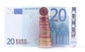 1 cent coin standing on top of stack of euro coins near 20 euro bank note Royalty Free Stock Photo