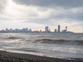 center of Batumi against the backdrop of big waves. The city against the backdrop of the rough sea. Houses in the distance. Big