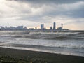 center of Batumi against the backdrop of big waves. The city against the backdrop of the rough sea. Houses in the distance.