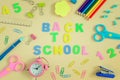 In the center of table the inscription is BACK TO SCHOOL, made in colored letters. Bright colored school and office Royalty Free Stock Photo