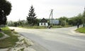 Center of a typical Ukrainian village. Asphalt road, houses, gardens, crossroad, rural street, people walking. Komarivka