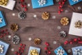 In the center of the wooden background Copy space. Around neatly laid out the twigs of red berries, small gift boxes Royalty Free Stock Photo