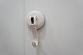 Centered Close-Up of White Plastic Suction Cup Hook Mounted on Smooth White Tiled Wall, Ideal for Bathroom Organization and Royalty Free Stock Photo