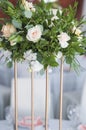 Centerpiece made of fresh flowers stands on the dinner table. Wedding day. Beautiful multicolored bouquet of flowers on a Royalty Free Stock Photo