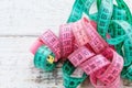 a centimeter-long ribbon of pink and green lies on a wooden table. the concept of a healthy lifestyle.