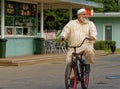 Central Asian elderly man rides a bicycle