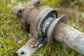Central bearing and shell from a propeller shaft. Removed from a car and lying in the grass. Rusty bearing outer face and end of a