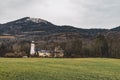 Central European country side autumn dramatic scenic view with field church and monastery buildings on Alps mountains background Royalty Free Stock Photo