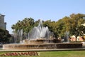 Central fountain, with several water jets from center to ends wifh flowers around and lawn Royalty Free Stock Photo