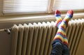 Central heating radiator and woman in striped socks