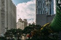 Central Jakarta cityscape with high rise, skyscrapers and hotel in tourist area with green trees with cloud in the bright sky.