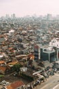 Central Jakarta Cityscape with high rise, skyscrapers and red tile hip roof local buildings with fog in the morning