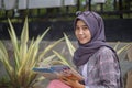 muslim asian student sitting holding book