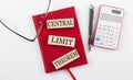 CENTRAL LIMIT THEOREM text on wooden block on red notebook