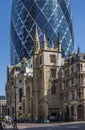 CENTRAL LONDON / ENGLAND - 18.05.2014 - The Gherkin sky-scraper is seen behind the St. Andrew Undercroft medieval church in London Royalty Free Stock Photo