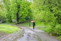 Central Park, New York city. Woman walking on a path holding an umbrella, rainy spring day Royalty Free Stock Photo