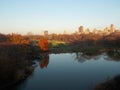 Central Park Pond with Autumn Trees and City Buildings Royalty Free Stock Photo