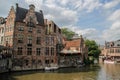 The central part of the house with a canal, bridge, medieval buildings and people walking