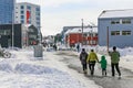 Central pedestrian street with modern building and walking peopl