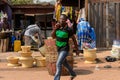 Unidentified Ghanaian man passes by the basins in local village