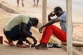 Unidentified Ghanaian man treats his friend's wound in local vi