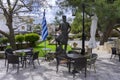 Central Square of Archanes village with the traditional coffee shops. Bronze statue of a cretan hero