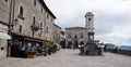 Central square of San Marino. Palace and statue of Liberty with street caffe and tourists walking on cloudy day Royalty Free Stock Photo
