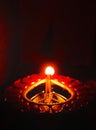Central symmetrical close up diwali oil clay lamp on dark orange black background Royalty Free Stock Photo