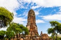 Ancient Siamese Temple Wat Phra Ram in Ayutthaya Historical Park, Thailand. Surrounded by trees; blue sky and clouds above.