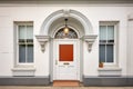 central white door, fanlight above, in stone facade