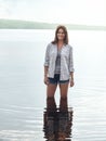 At the centre of natures beauty. Portrait of an attractive young woman standing in a lake. Royalty Free Stock Photo