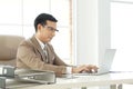 Asian handsome senior successful businessman using computer laptop to researching and working. sit in the private office Royalty Free Stock Photo