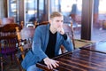 CEO with smartwatch waiting order in cafe and thinking about new Royalty Free Stock Photo