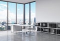 A CEO workplace in a modern corner panoramic office in New York city. A white desk with a laptop, white leather chair and a booksh Royalty Free Stock Photo