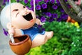 Ceramic baby dolls play swings happily in the garden.