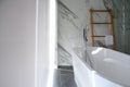 Ceramic bathtub in modern bathroom, curtain roll is close. Dark tone