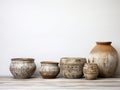 Ceramic beige and brown different pots stand in a row on wooden light background, Scandinavian style.
