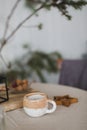 Ceramic beige coffee cup on a table with beige linen tablecloth. Scandinavian interior.