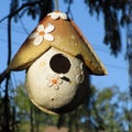 Ceramic Birdhouse hanging in a tree.