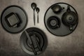 Ceramic black dishes with a set of cutlery. Empty black dishes for breakfast or dinner or for tea on a black background. View from Royalty Free Stock Photo