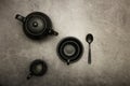 Ceramic black dishes with a set of cutlery. Empty black dishes for breakfast or dinner or for tea on a black background. View from Royalty Free Stock Photo