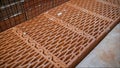 Damaged ceramic block of orange color. Ceramic blocks. Worker puts a red ceramic block. Building a house from a red ceramic block